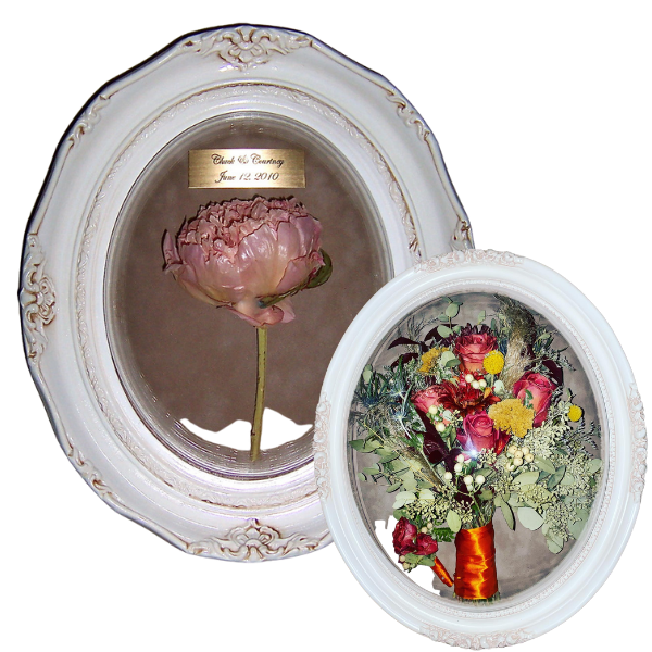two preserved floral keepsakes in white oval frames
